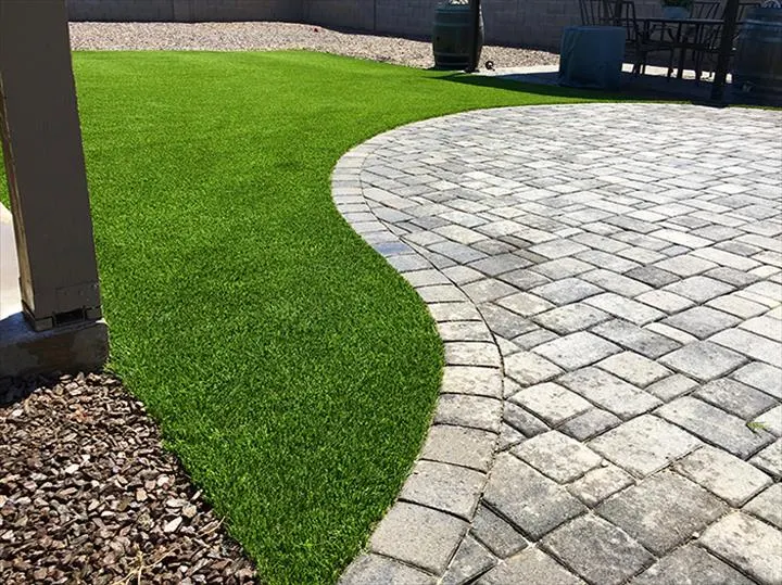 Artificial turf curving around a circular paver patio